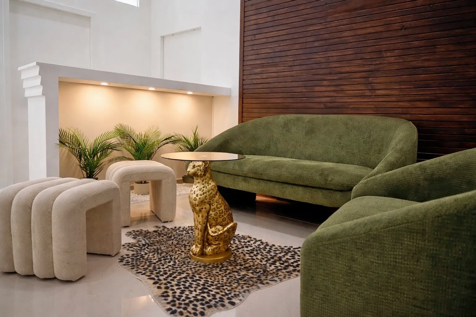 Le salon d'accueil de l'institut : canapés en velours vert, plantes et lumière douce